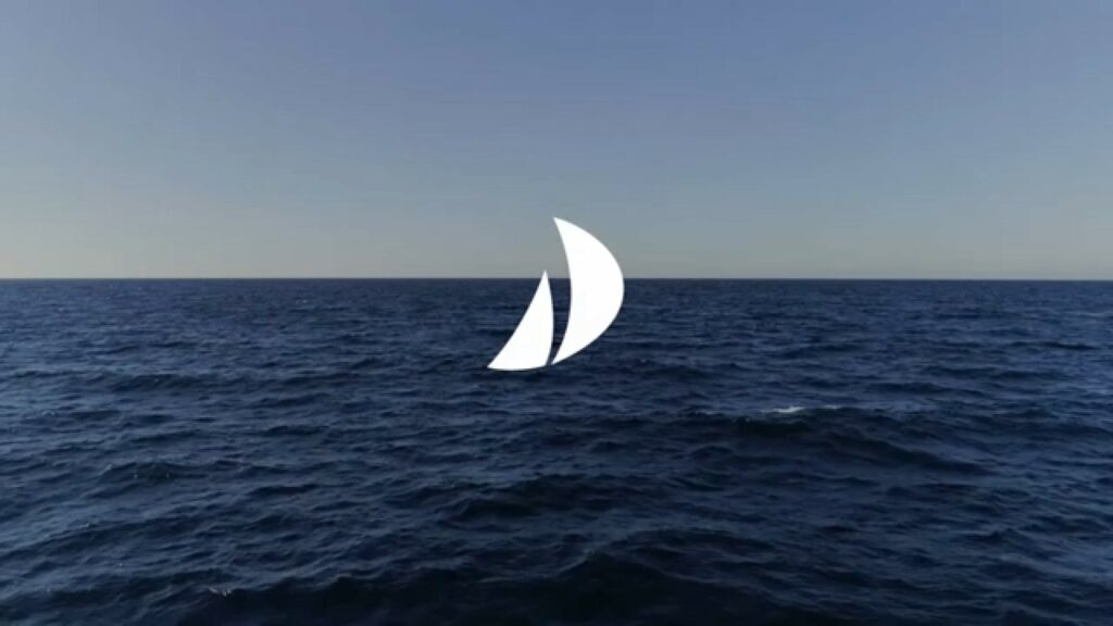 Isotipo de vela superpuesto sobre una fotografía del mar abierto en el horizonte