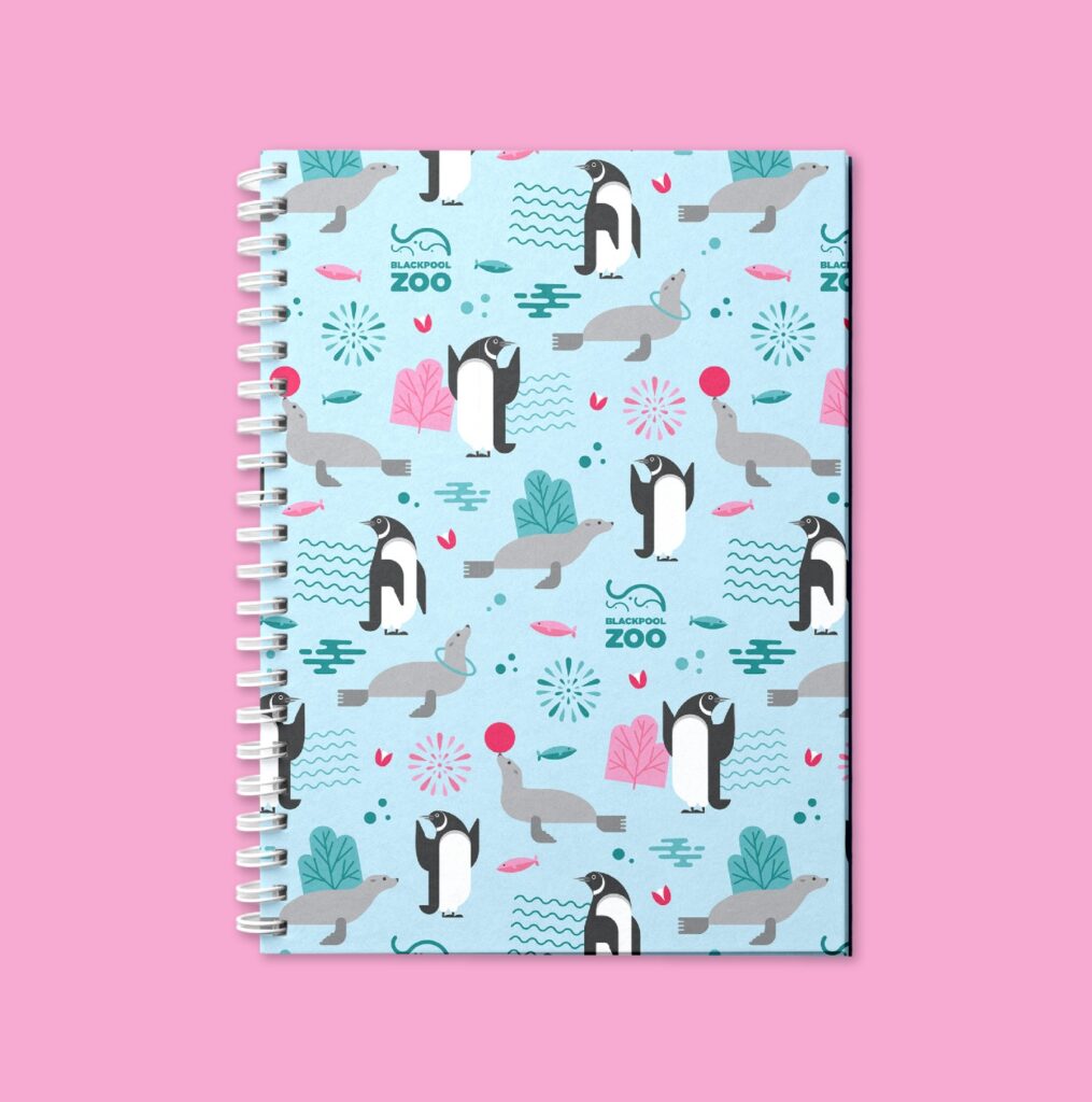 Cuaderno con un patrón de pingüinos sobre fondo rosa