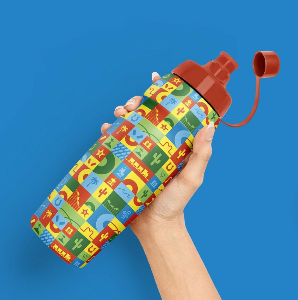 Mano sosteniendo una botella reutilizable con un estampado de temática western en colores vivos