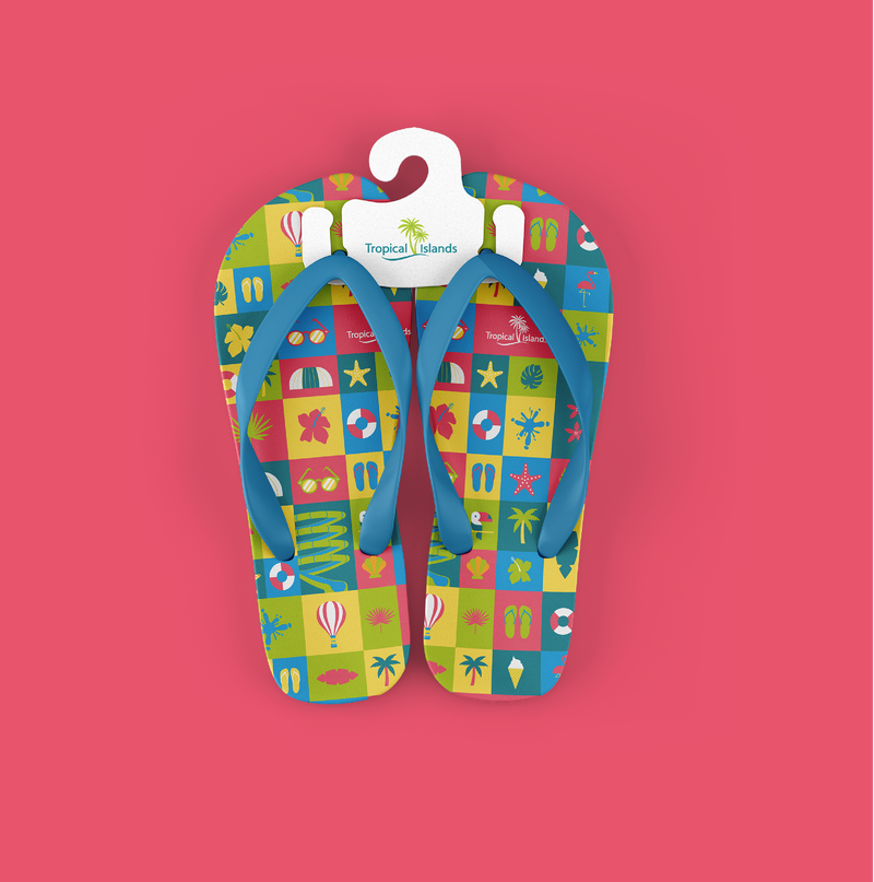 Chanclas con estampado de iconos tropicales (flamenco, piña, gafas de sol, tobogán) en rosa, amarillo, verde y azul, con una etiqueta del logotipo Tropical Islands