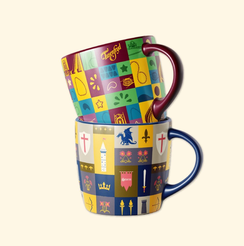 Dos tazas apiladas con un patrón colorido de iconos medievales y el logotipo de Tusenfryd
