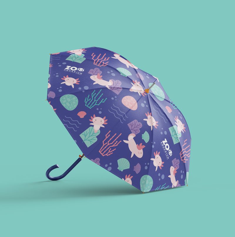 Paraguas con estampado de ajolotes, corales y conchas en tonos morados y rosas, con el logotipo Zoo Aquarium Madrid